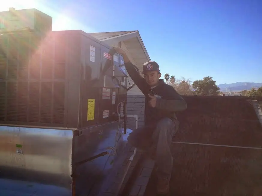 HVAC technician performing Air Duct Cleaning on a rooftop unit in Englewood